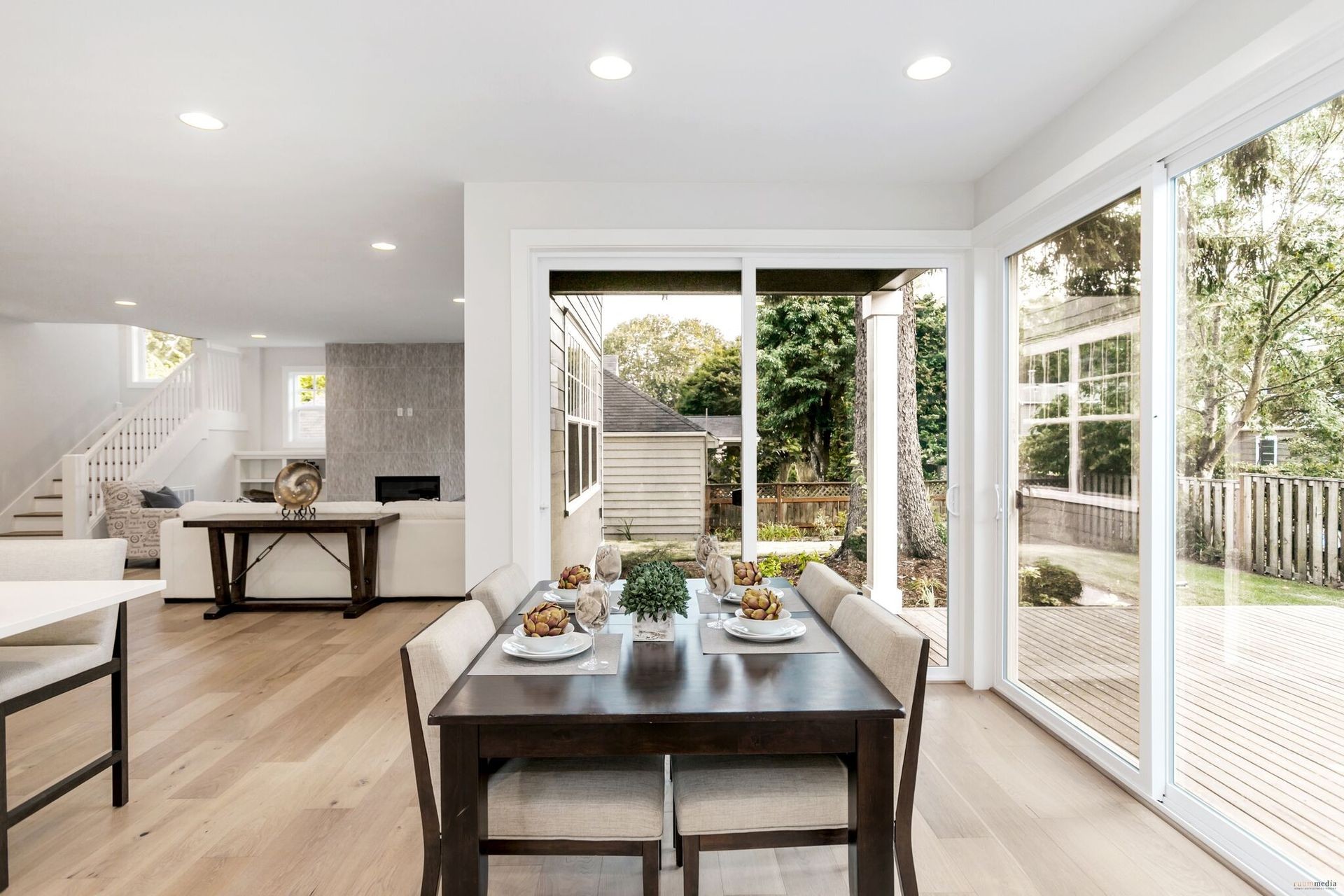 Spacious and modern dining room with natural light in a sustainable net-zero energy home, featuring elegant hardwood floors and contemporary design